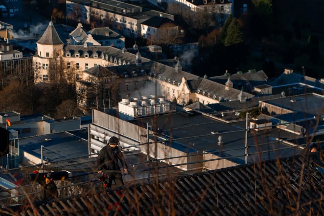 Roofer working on a rooftop, the point where a homeowner's inquiry first turns into a real job to manage