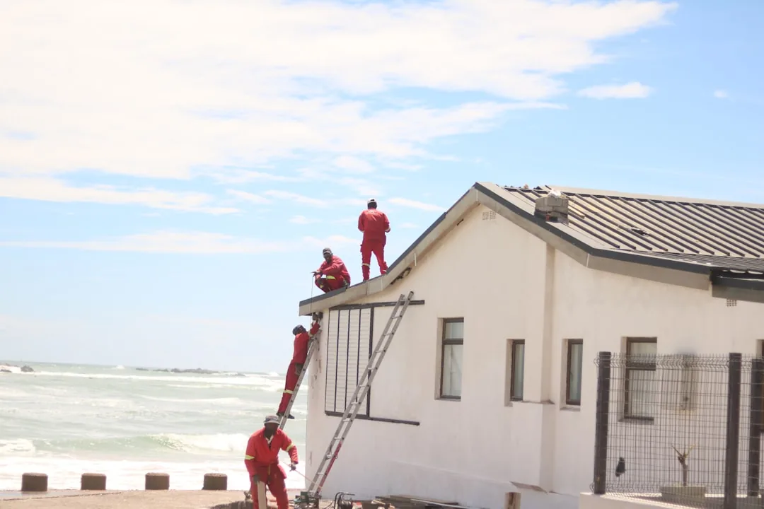 Roofers in safety gear working on a residential roof, the same crew a paid ad or a retargeting campaign is trying to reach a homeowner about.