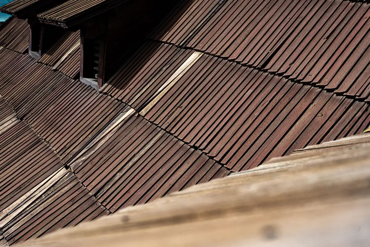 Close-up of aged wooden roof shingles showing natural texture and architectural detail.