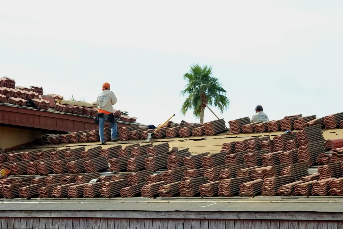 Roofing crew installing terra cotta roof tiles on a residential home, the real work behind any lead-gen results chart.